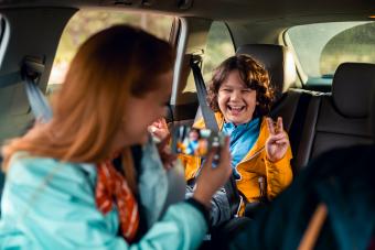 لقطة مقرّبة لأم تلتقط صورة لابنها في المقعد الخلفي