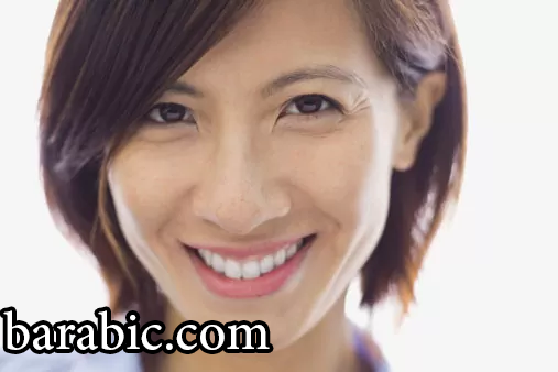 امرأة مبتسمة بشعر مفترق على الجانب