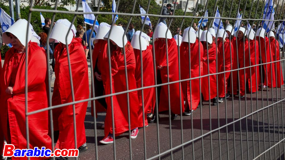 متظاهرون يرتدون زي خادمات من الكتاب البائس "حكاية الخادمة" يحتجون في تل أبيب يوم الإثنين.