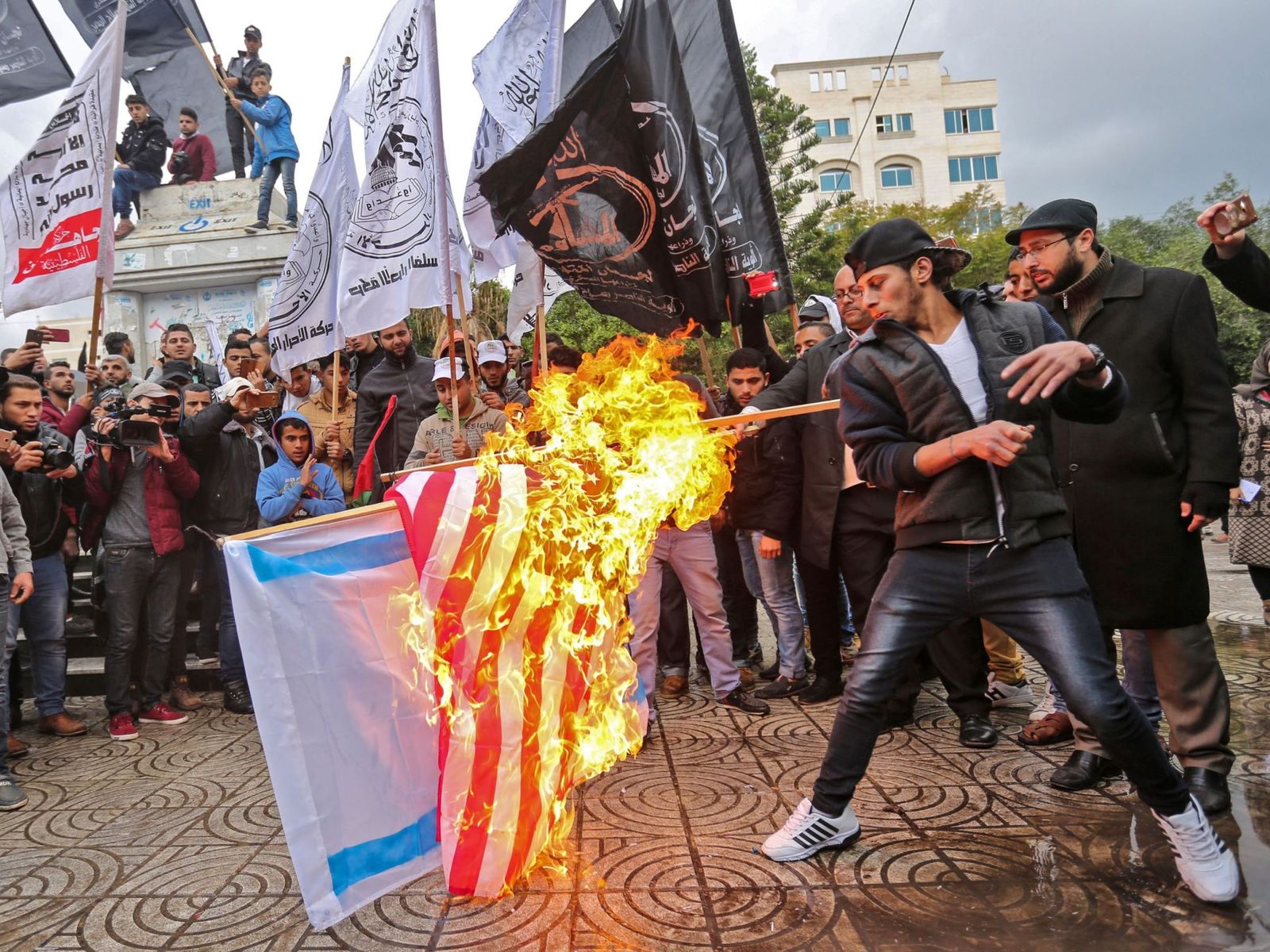 Palestinian protesters burn the US and Israeli flags in Gaza City